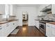 Bright kitchen features white cabinets, wood countertops, stainless steel appliances, and a view into the dining room at 1612 S Logan St, Denver, CO 80210