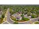 An aerial view of a suburban neighborhood showcasing a property with lush greenery and mature trees at 12814 Forest Cir, Thornton, CO 80241