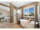 Spa-like bathroom with soaking tub, stand-up shower, and a picturesque window view at 12814 Forest Cir, Thornton, CO 80241