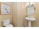 Charming powder room features a pedestal sink, an elegant mirror and floral artwork at 12814 Forest Cir, Thornton, CO 80241