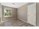 This bedroom has warm wood-look floors, a bright window, and a clean white door at 12814 Forest Cir, Thornton, CO 80241
