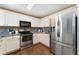 Modern kitchen featuring stainless steel appliances, white cabinetry, and hardwood flooring at 12814 Forest Cir, Thornton, CO 80241