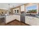 Bright kitchen featuring white cabinets, tile countertops, and stainless steel appliances with hardwood floors at 12814 Forest Cir, Thornton, CO 80241
