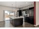 Modern kitchen with dark cabinetry, island, and stainless steel appliances at 10081 Truckee St, Commerce City, CO 80022