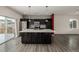 Modern kitchen with dark cabinetry, stainless steel appliances, and large island at 10081 Truckee St, Commerce City, CO 80022
