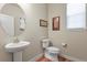 Cozy powder room with a pedestal sink, round mirror, and decorative accents at 23893 E Minnow Cir, Aurora, CO 80016