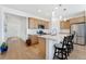 Modern kitchen featuring an island with bar seating, stainless steel appliances, and wood floors at 18953 E 97Th Ave, Commerce City, CO 80022