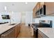 Contemporary kitchen with stainless steel appliances, light wood cabinets, and a center island at 18953 E 97Th Ave, Commerce City, CO 80022