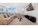 Bright living room features large windows, plush sectional sofa and modern entertainment center at 18953 E 97Th Ave, Commerce City, CO 80022
