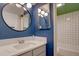 This stylish bathroom features a modern vanity with a sink, a round mirror, and subway tile in the shower at 777 N Washington St # 802, Denver, CO 80203