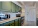 This kitchen features updated appliances, green cabinets, and subway tile backsplash at 777 N Washington St # 802, Denver, CO 80203