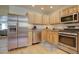 Spacious kitchen featuring stainless steel appliances, wood cabinets, and granite countertops at 1825 W 32Nd Ave, Denver, CO 80211