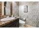 A creatively tiled half-bathroom with modern fixtures, and stylish decor at 9140 E 29Th Ave, Denver, CO 80238