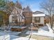 Snowy front exterior of a charming house with a turret, bay window, and well-maintained landscaping at 9140 E 29Th Ave, Denver, CO 80238