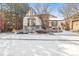 Snowy front exterior of a charming house with a turret, bay window, and well-maintained landscaping at 9140 E 29Th Ave, Denver, CO 80238