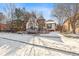 Snowy front exterior of a charming house with a turret, bay window, and well-maintained landscaping at 9140 E 29Th Ave, Denver, CO 80238