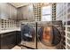 Modern laundry room featuring sleek washer and dryer units with storage at 9140 E 29Th Ave, Denver, CO 80238