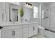 Bright bathroom featuring double sinks, white cabinets, and a glass enclosed shower at 4040 Eaton Park St, Aurora, CO 80019