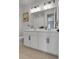Bright bathroom with double sink vanity, modern lighting and neutral tile at 4040 Eaton Park St, Aurora, CO 80019