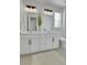 Bright bathroom featuring double sinks, white cabinets, and a glass enclosed shower at 4040 Eaton Park St, Aurora, CO 80019