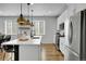 Contemporary kitchen featuring white cabinets, stainless steel appliances, and a spacious island with pendant lights at 4040 Eaton Park St, Aurora, CO 80019