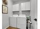 Clean laundry room with white washer, dryer, and cabinets for organized storage at 4040 Eaton Park St, Aurora, CO 80019