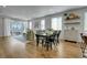 Open-concept living area featuring light hardwood floors, dining area, and sliding glass doors to the outside at 4040 Eaton Park St, Aurora, CO 80019
