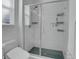 Modern bathroom shower with glass door, hexagon tile floor, and chrome shower fixtures at 4040 Eaton Park St, Aurora, CO 80019