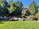 Large backyard featuring stone accents, patio furniture, and mature trees at 3188 Lynwood Ave, Highlands Ranch, CO 80126