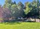 Relaxing backyard patio area with mature trees and serene landscaping at 3188 Lynwood Ave, Highlands Ranch, CO 80126