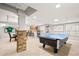 Finished basement with a pool table, bar area, and decorative stone accents at 3188 Lynwood Ave, Highlands Ranch, CO 80126