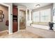 Bathroom showcasing a soaking tub, glass enclosed shower, and tile flooring at 3188 Lynwood Ave, Highlands Ranch, CO 80126