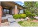 Inviting front porch with brick accents, lush greenery, and stone details, creating a warm and welcoming entrance at 3188 Lynwood Ave, Highlands Ranch, CO 80126