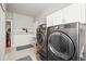 Well-equipped laundry room with modern washer and dryer, plus storage cabinets at 3188 Lynwood Ave, Highlands Ranch, CO 80126