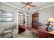 Well-lit office with a ceiling fan, a large dark wood desk, and custom shelving for storage and organization at 3188 Lynwood Ave, Highlands Ranch, CO 80126
