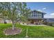 Lush backyard with mature trees, a well-manicured lawn, and a covered patio area for outdoor living at 1977 S Urban St, Lakewood, CO 80228
