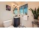 Stylish bathroom with dark blue vanity, patterned floor tiles, and modern fixtures at 1977 S Urban St, Lakewood, CO 80228