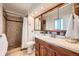 This updated bathroom features a tiled stand up shower and a dark wood vanity with a large mirror at 1977 S Urban St, Lakewood, CO 80228
