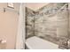 Elegant bathroom featuring a shower and tub combination with decorative tile and a shower curtain at 1977 S Urban St, Lakewood, CO 80228