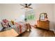 Comfortable bedroom with wood floors, a dresser, large window, and colorful patterned bedding at 1977 S Urban St, Lakewood, CO 80228
