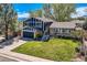 Charming two-story home boasts a lush front yard, blue siding, and inviting entryway at 1977 S Urban St, Lakewood, CO 80228