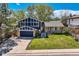 Charming two-story home with a well-manicured lawn, attached garage, and inviting front entrance at 1977 S Urban St, Lakewood, CO 80228