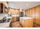 Well-lit kitchen featuring a central island, stainless steel appliances, and light wood cabinetry at 1977 S Urban St, Lakewood, CO 80228