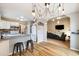 Open-concept kitchen and living area with modern lighting, hardwood floors, and barstool seating at the kitchen counter at 11376 Forest Dr, Thornton, CO 80233