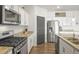 Well-lit kitchen featuring stainless steel appliances, granite countertops, and wood flooring at 562 Twilight Ct, Fort Lupton, CO 80621