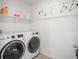 Bright laundry room with modern washer and dryer and shelving for storage at 562 Twilight Ct, Fort Lupton, CO 80621