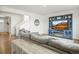 Bright living room featuring hardwood floors, a stylish entertainment center, and a staircase at 562 Twilight Ct, Fort Lupton, CO 80621