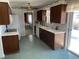 Kitchen with wood cabinets, tiled floor and view into living room at 5922 S Otis Ct, Littleton, CO 80123