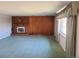 Inviting living room boasts a brick fireplace and wood paneled accent wall at 5922 S Otis Ct, Littleton, CO 80123