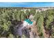 An aerial view of the green roofed home surrounded by lush, mature trees at 34480 Pine Ridge Cir, Elizabeth, CO 80107